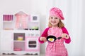 Little girl playing with toy kitchen Royalty Free Stock Photo