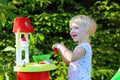 Little girl playing with toy kitchen outdoors Royalty Free Stock Photo