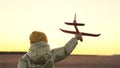 little girl playing with toy plane at sunset sky, happy family, childhood dream of flying, cheerful child running around Royalty Free Stock Photo