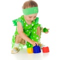 Little girl is playing with toy pyramid Royalty Free Stock Photo