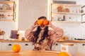 Little girl playing with two oranges fruit instead eyes on kitchen. Kid having fun, cooking wearing apron Royalty Free Stock Photo