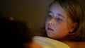 little girl is playing video games in tablet at night, internet addiction and insomnia of children