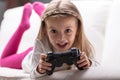 Little girl playing videogames at home