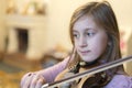 Little girl playing the violin at home. Child or little girl playing violin indoors at home Royalty Free Stock Photo