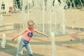 Little girl playing with water in city fountain. Royalty Free Stock Photo