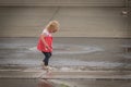 Little Girl Playing in Water Flowing Through the Gutter After Rain Storm Royalty Free Stock Photo