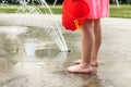 Little girl playing at water splash pad fountain in the park playground during hot summer day Royalty Free Stock Photo