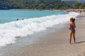 A little girl playing with waves on the shore in Oludeniz of Fethiye.