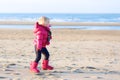 Little girl playing on winter beach Royalty Free Stock Photo