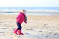 Little girl playing on winter beach Royalty Free Stock Photo