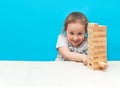 Little girl playing with wooden jenga game