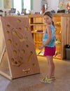 Little girl playing a wooden maze game Mouse in the cheese. Vintage board labyrinth game with ropes