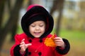 Little girl playing with yellow leaf in autumn park Royalty Free Stock Photo