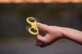 Little girl is playing a yellow spinner