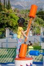 Little Girl Plays American Gladiator and Swings the Stick. Young Female Kid Playing Joust Games