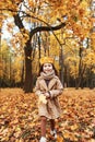 Little Girl Plays In The Autumn Leaves in park