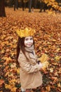 Little Girl Plays In The Autumn Leaves in park