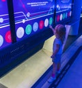 Little girl plays with buttons of the interactive wall. Technology