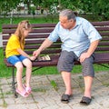 Little girl plays chess with dad in the park on a bench in the fresh air. Chess day. Educational, educational outdoor Royalty Free Stock Photo