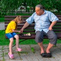 Little girl plays chess with dad in the park on a bench in the fresh air. Chess day. Educational, educational outdoor Royalty Free Stock Photo
