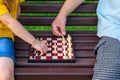 Little girl plays chess with dad in the park on a bench in the fresh air. Chess day. Educational, educational outdoor Royalty Free Stock Photo