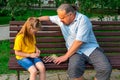 Little girl plays chess with dad in the park on a bench in the fresh air. Chess day. Educational, educational outdoor Royalty Free Stock Photo