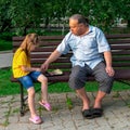 Little girl plays chess with dad in the park on a bench in the fresh air. Chess day. Educational, educational outdoor Royalty Free Stock Photo