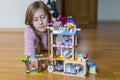 Little girl plays with a children`s constructor at home. Little girl playing with lots of colorful plastic blocks constructor and Royalty Free Stock Photo