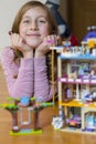 Little girl plays with a children`s constructor at home. Little girl playing with lots of colorful plastic blocks constructor and Royalty Free Stock Photo