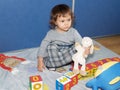 The little girl plays with cubes, sitting on a floor Royalty Free Stock Photo