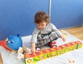 The little girl plays with cubes, sitting on a floor Royalty Free Stock Photo