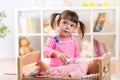 Little girl plays doctor examining a doll patient Royalty Free Stock Photo