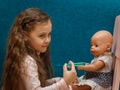 Little girl plays doctor, makes an injection to the doll Royalty Free Stock Photo