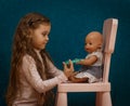 Little girl plays doctor, makes an injection to the doll Royalty Free Stock Photo