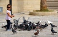 A little girl plays feeding pigeons in Heraklion Royalty Free Stock Photo