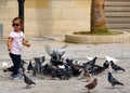 A little girl plays feeding pigeons in Heraklion Royalty Free Stock Photo