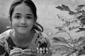 Little girl plays with flowers in a garden