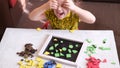 Little girl plays with geometric mosaic details and has fun and dabbles. game for creativity. Leisure of child, development of fi