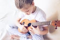 A little girl plays guitar in her home. Selective focus. Close-up. The concept of music and art Royalty Free Stock Photo