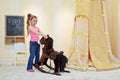 Little girl plays with hobbyhorse