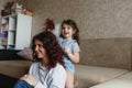 a little girl plays at home with her mother doing her hair while combing her mother s long hair Royalty Free Stock Photo