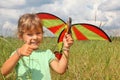 Little girl plays kite on meadow with ok gesture Royalty Free Stock Photo