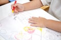 Little girl plays and learns to coloring Crayon on the paper in the ice-cream restaurant., Bangkok, Thailand