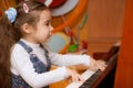 Little girl plays piano Royalty Free Stock Photo