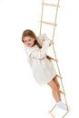 Little girl plays on a rope ladder.