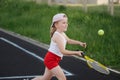 Happy girl plays tennis on court outdoors Royalty Free Stock Photo