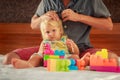 little girl plays toy constructor father brushes her hair Royalty Free Stock Photo