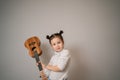 Little girl plays ukulele. Creative development in children. Musical education from childhood. Teaching music online at