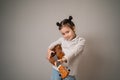 Little girl plays ukulele. Creative development in children. Musical education from childhood. Teaching music online at