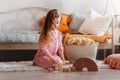 Little girl plays with wooden cubes on the floor in the children`s bedroom Royalty Free Stock Photo